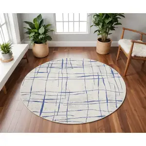 Photo of 8' Ivory and Blue Abstract Distressed Round Rug