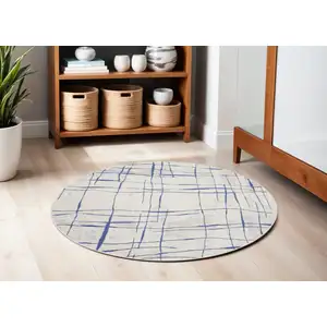 Photo of 5' Ivory and Blue Abstract Geometric Distressed Round Rug