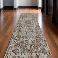 Photo of 12' Tan Blue and Brown Oriental Power Loom Worn Faded Runner Rug With Fringe