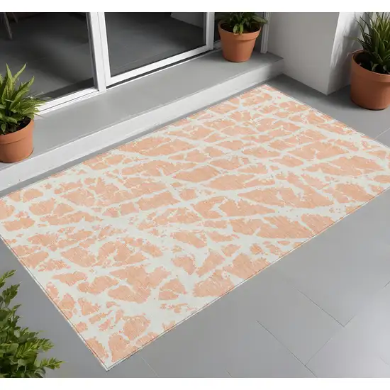 3' X 4' Peach and Ivory Abstract Washable Non Skid Indoor Outdoor Area Rug Photo 1