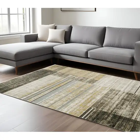 6' X 9' Beige Charcoal Brown Grey Tan Gold And Blue Geometric Power Loom Stain Resistant Area Rug With Fringe Photo 1