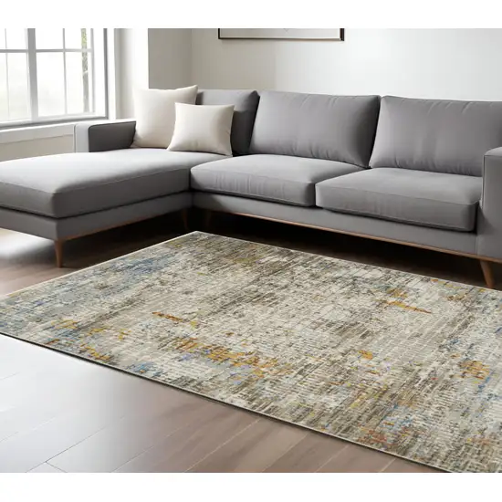 6' X 9' Beige Grey Brown Gold Red And Blue Abstract Power Loom Stain Resistant Area Rug With Fringe Photo 1