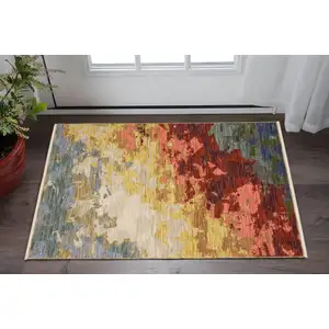 Photo of Beige Red And Yellow Abstract Area Rug With Fringe