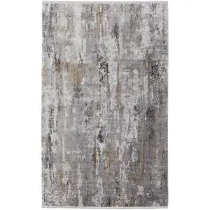 Photo of Gray Ivory and Gold Abstract Power Loom Area Rug With Fringe