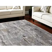 Photo of Gray Ivory and Gold Abstract Power Loom Area Rug With Fringe