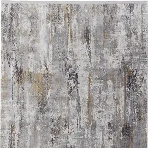 Photo of Gray Ivory and Gold Abstract Power Loom Area Rug With Fringe