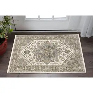 Photo of Ivory And Gold Medallion Distressed Area Rug With Fringe