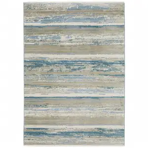 Photo of Ivory Beige Grey Blue And Tan Abstract Power Loom Stain Resistant Area Rug With Fringe