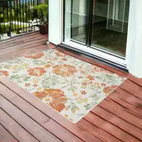 Photo of Ivory Green and Orange Floral Stain Resistant Indoor Outdoor Area Rug