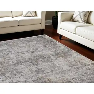 Photo of Ivory Taupe and Gray Abstract Power Loom Distressed Area Rug With Fringe