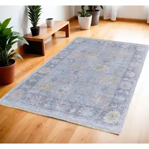 Photo of Orange Blue and Gold Floral Hand Woven Distressed Area Rug With Fringe