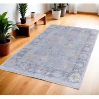 Photo of Orange Blue and Gold Floral Hand Woven Distressed Area Rug With Fringe