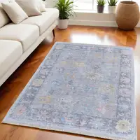 Photo of Orange Blue and Gold Floral Hand Woven Distressed Area Rug With Fringe