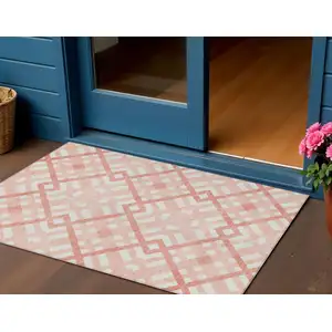 Photo of Salmon Peach And Ivory Geometric Washable Indoor Outdoor Area Rug