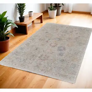 Photo of Tan Brown and Blue Floral Hand Woven Distressed Area Rug With Fringe