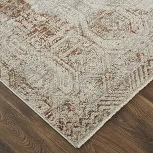 Photo of Tan Ivory And Orange Floral Power Loom Distressed Area Rug With Fringe