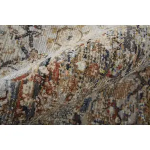 Photo of Tan Orange And Blue Floral Power Loom Distressed Area Rug With Fringe