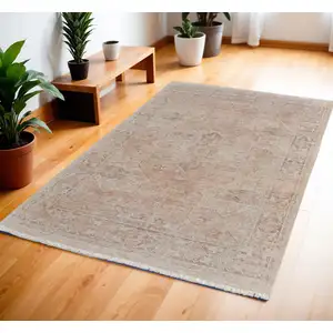 Photo of Tan Orange and Ivory Oriental Hand Woven Distressed Area Rug With Fringe