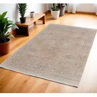 Photo of Tan Orange and Ivory Oriental Hand Woven Distressed Area Rug With Fringe