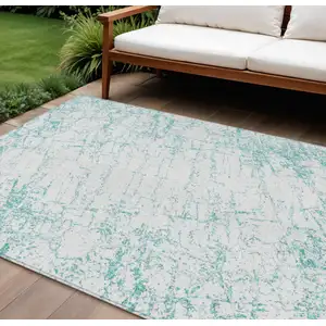 Photo of Teal Blue And Ivory Abstract Washable Indoor Outdoor Area Rug