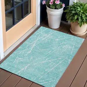 Photo of Teal Blue And Ivory Abstract Washable Indoor Outdoor Area Rug