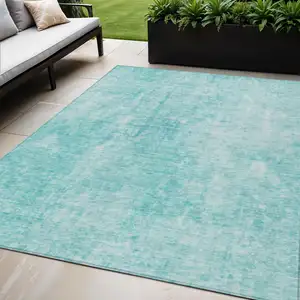 Photo of Teal Blue And Ivory Abstract Washable Indoor Outdoor Area Rug