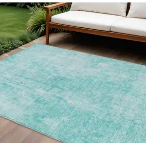 Photo of Teal Blue And Ivory Abstract Washable Indoor Outdoor Area Rug