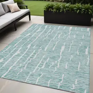 Photo of Teal Blue And Ivory Abstract Washable Indoor Outdoor Area Rug